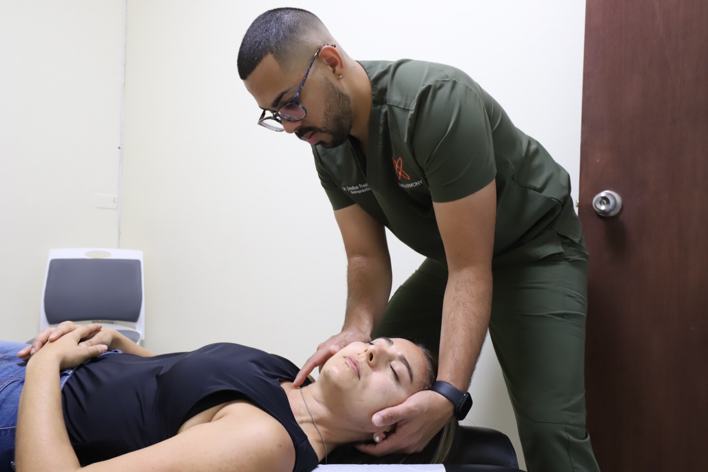 Dr. Pesante ajustando el cuello de una paciente para aliviar dolores de cabeza