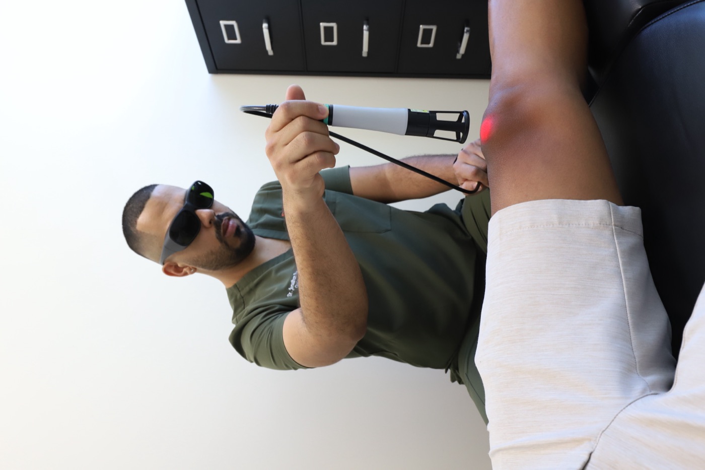 Dr. Pesante aplicando terapia láser en la rodilla
